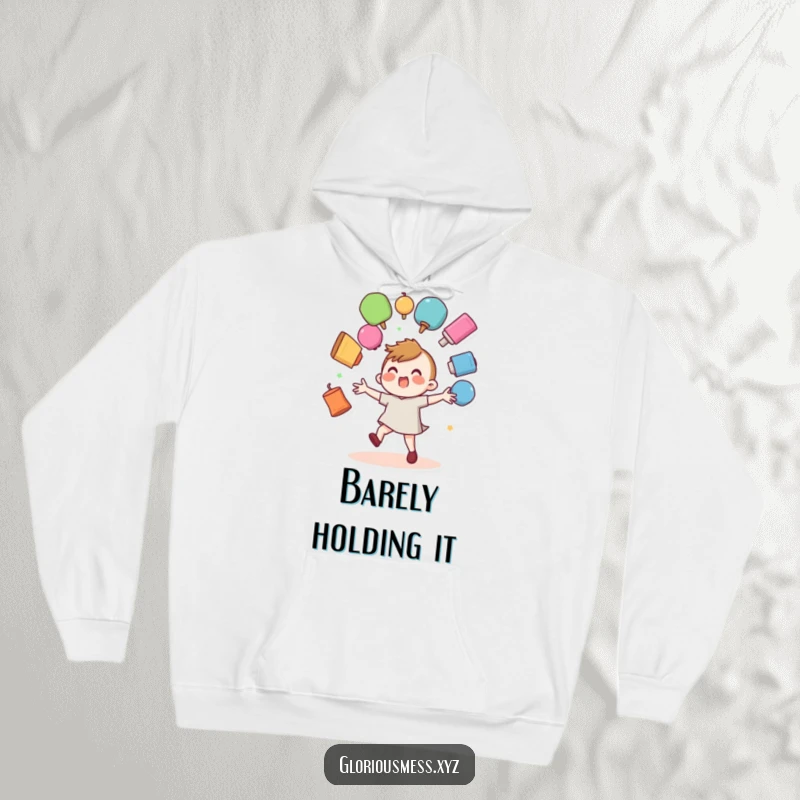 Funny hoodie featuring a wobbly character precariously juggling numerous colorful objects, looking like they might fall.