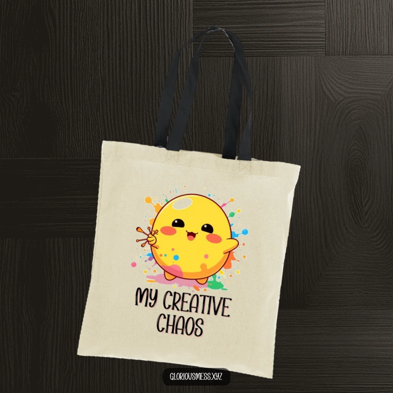 Funny tote bag featuring a bright yellow blob character enthusiastically splattering colorful paints, ideal for art supplies or daily essentials.